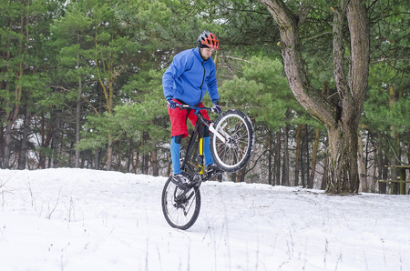 Cyclist on the mountain bike, extreme winter riding in the forest. A man rides a bicycle.