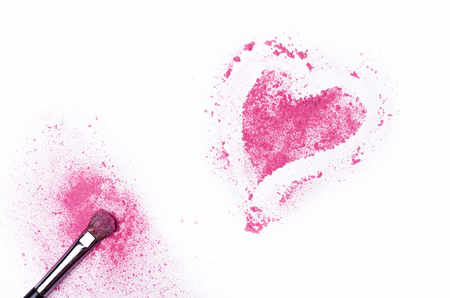 Heart shaped crushed eye shadows with brush isolated on white background. Pink shadows on white table, free space.の写真素材