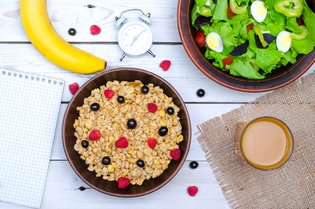 Healthy food: muesli, lettuce and fresh juice on a wooden table. The concept of a healthy breakfast.の写真素材