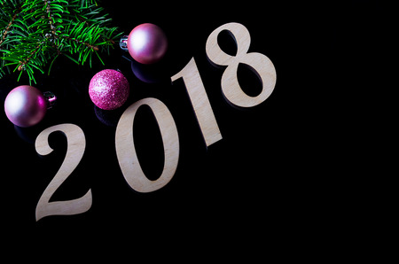 New Year's composition: Christmas balls and sign 2018 isolated on a black background. Background for...