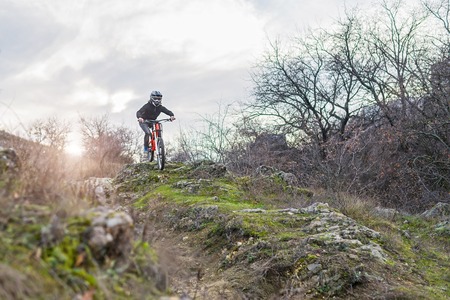 Professional daunhilschik riding from the mountain top to mountain biking, free space. Extreme sports, mtb.の写真素材