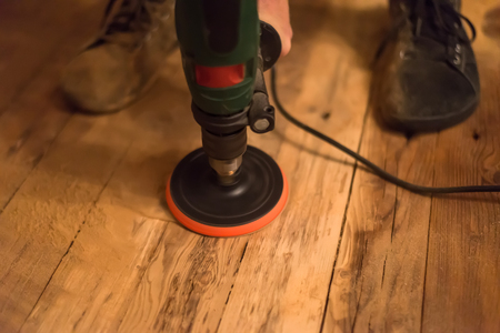 Worker grinds the wood of angular grinding machine. Carpentry, wooden background for your textの写真素材