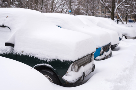 Machines covered with snow, winter snowstorm. Vehicles are covered with snow, bad weather.の写真素材