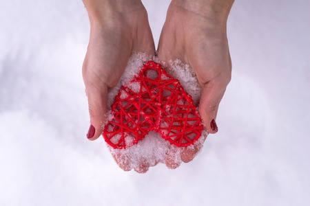 Concept for Valentine's Day, wedding: hands holding a red heart. Romantic background for cards.の写真素材