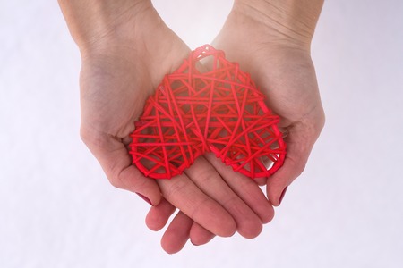 Concept for Valentine's Day, wedding: hands holding a red heart. Romantic background for cards.の写真素材