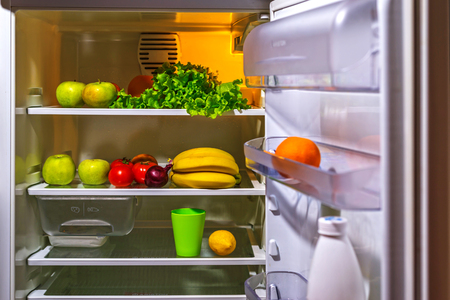 Open refrigerator with vegetarian food. Ingredients for a fresh diet breakfast.の写真素材