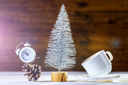 New Year's composition: a clock and a Christmas tree on a wooden background. Christmas background with copy space.の写真素材