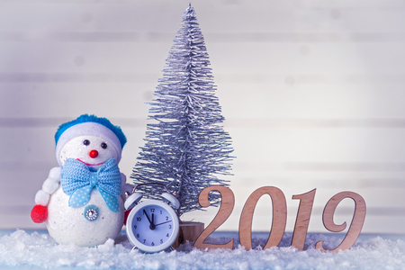 New Year's composition: clock, snowman, inscription 2019 and Christmas tree on a wooden background. Christmas background with copy space.の写真素材
