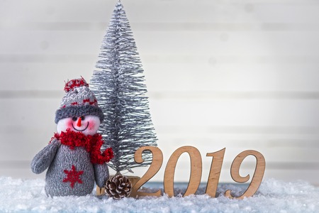 New Year's composition: snowman, inscription 2019 and Christmas tree on a wooden background. Christmas background with copy space.の写真素材