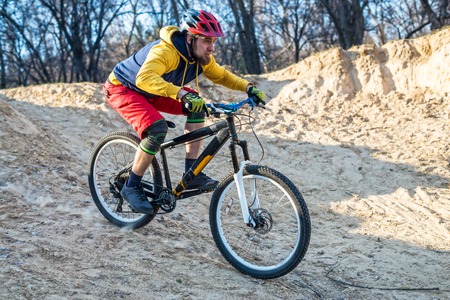 Mountain bike cyclist descending from the drop, free space. Active lifestyle, mtb.の写真素材