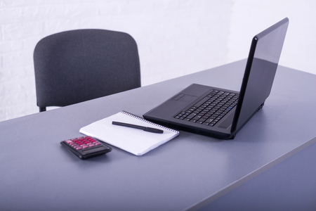 Laptop on the office desk. Workplace: laptop, calculator, notebook and pen.の写真素材