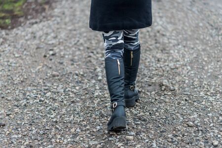 Women's boots walking on the road close-up. Winter shoes.の写真素材