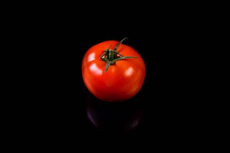 Red tomato isolated on a black background. Vegetable.の写真素材