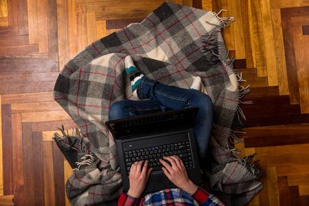 Woman typing on laptop on the floor, top view. The concept of remote work. Freelance. Work at home....
