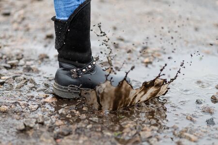 Children's dirty boot in a puddle. Dirty shoes.の写真素材