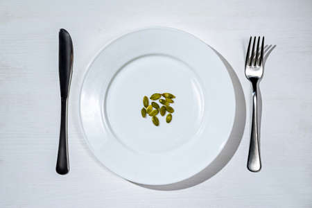 Healthy food concept: pumpkin seeds on a plate.