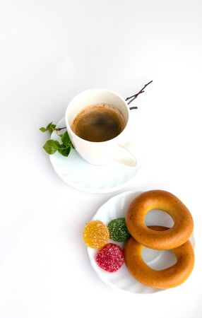 Coffee, plate, bagels, marmalade, sprig with green leaves, on a white backgroundの写真素材