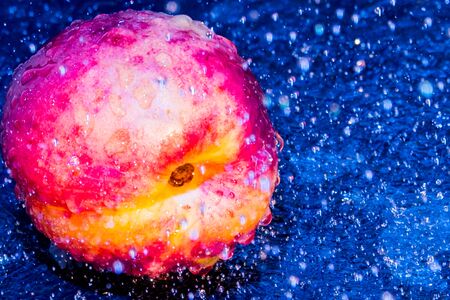 nectarines drops of water on a blue backgroundの写真素材