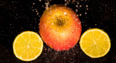 apple, laim, drops of water on a black backgroundの写真素材