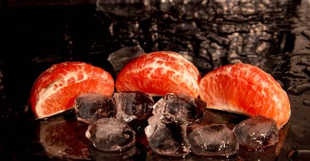 grapefruit, slices, with ice on a black background