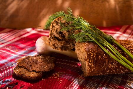 Gray bread on a tablecloth with dill, garlic, wooden tableの写真素材