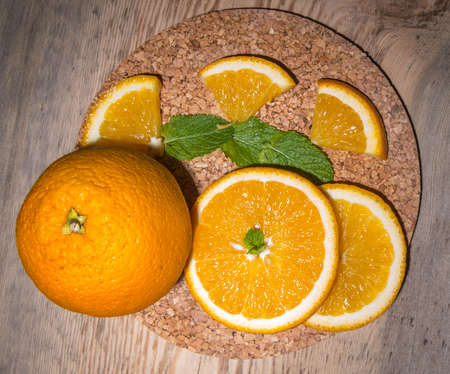 Orange slices, whole orange, on a wooden table