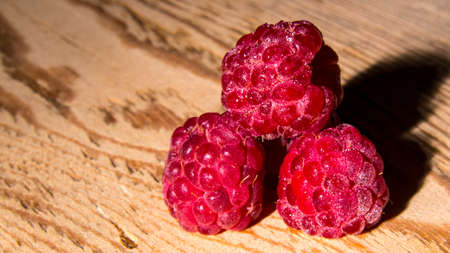 red raspberries on wooden background