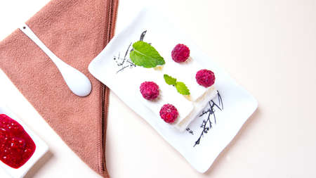 A plate of ice cream with raspberry jam on the table
