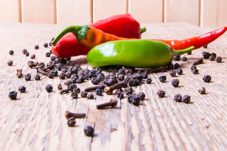 Hot chili pepper red, green, yellow scattered on an old wooden table