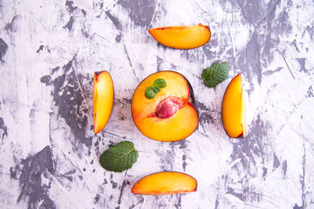 Plum whole and sliced, with the slices with mint leaves