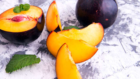 Plum whole and sliced, with the slices with mint leaves