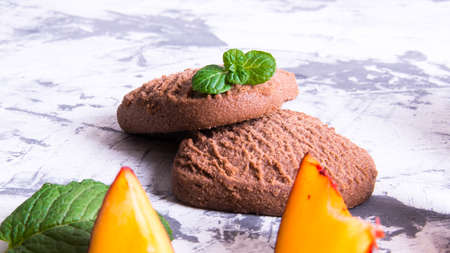 Shortbread cookies in the shape of a heart and plum slices with mint leaves