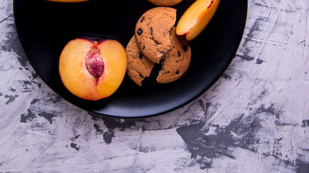 Shortbread and plum sliced on a black plateの写真素材