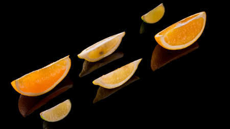 Lime lemon orange slices on a black background close up