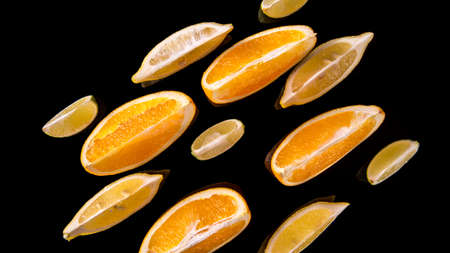 Lime lemon orange slices on a black background close up
