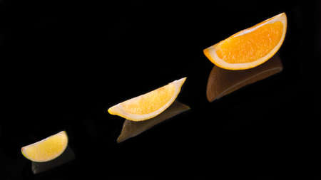 Lime lemon orange slices on a black background close up