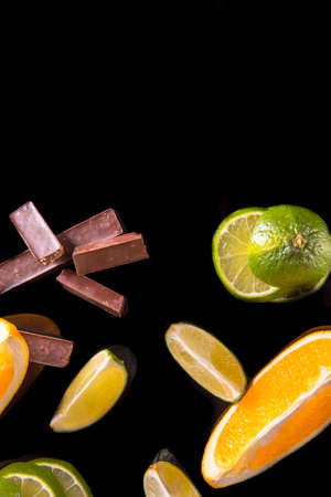 Slices of lime orange halves on a black background close upの写真素材