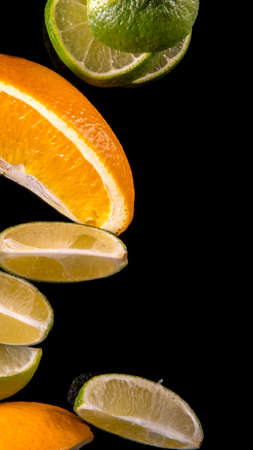 Lime lemon orange slices on a black background close upの写真素材