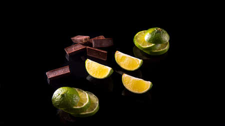 Slices and slices of lime lemon on a black background close upの写真素材