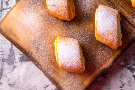 Baking strudel, rolls dusted with powder on a black and white background, on a wooden Board with a...