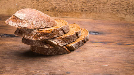 Sliced rye bread on an old wooden table, close-up
