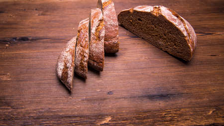 Sliced rye bread on an old wooden table, close-up