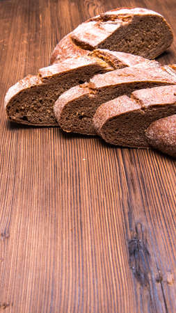 Sliced rye bread on an old wooden table, close-up