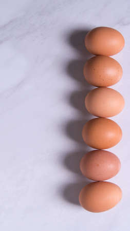 Close-up of fresh brown eggs, in one line, top view, copy space, background, advertising