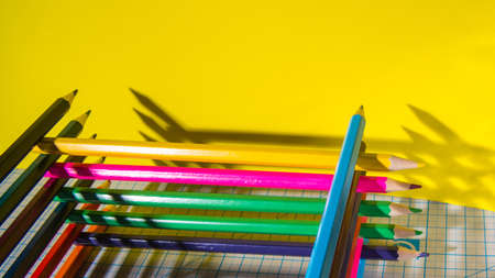 Color pencils with hard shadows on the cutting Mat, in a low key, copy space close-up, side view