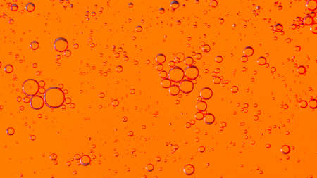 Oil bubbles on the water surface in motion, on a yellow-red background, macro, splash screen, template, copy spaceの写真素材