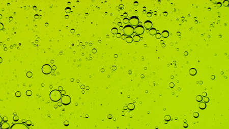 Oil bubbles on the water surface in motion, on a light green background, macro, splash screen,...