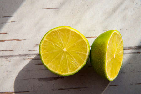 Two lime halves close-up, copy space, pattern, rough shadows