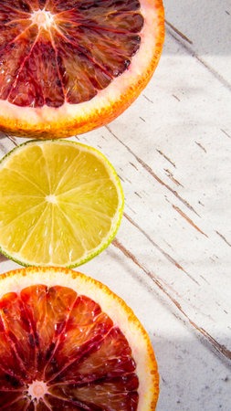 Red orange lime sliced and whole, on black background, close-up, copy space, template, postcardの写真素材