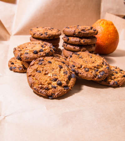 Cookies with chocolate icing orange, on gray packaging paper, copy space, templateの写真素材